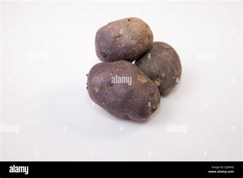 Purple Vitelotte Potatoes Isolated Over White Background Stock Photo