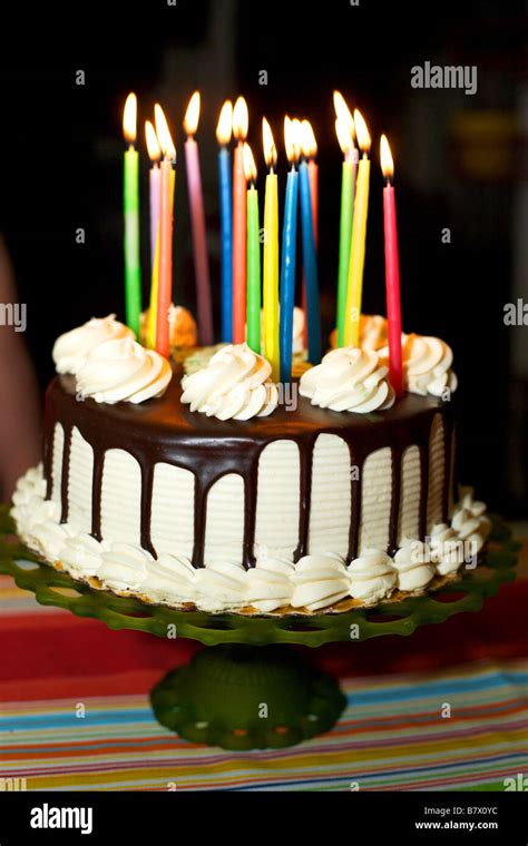 A Birthday Cake With Lit Candles White Frosting And Chocolate Dripping