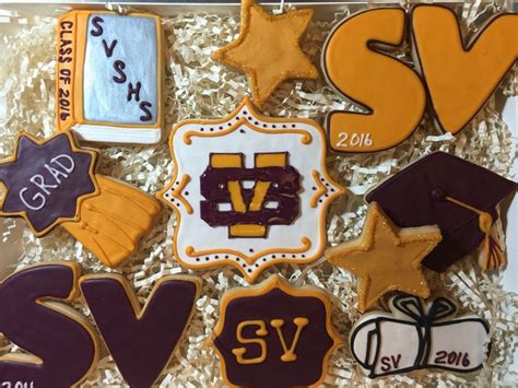 Decorated Cookies In The Shape Of Graduation Caps And Gowns Are