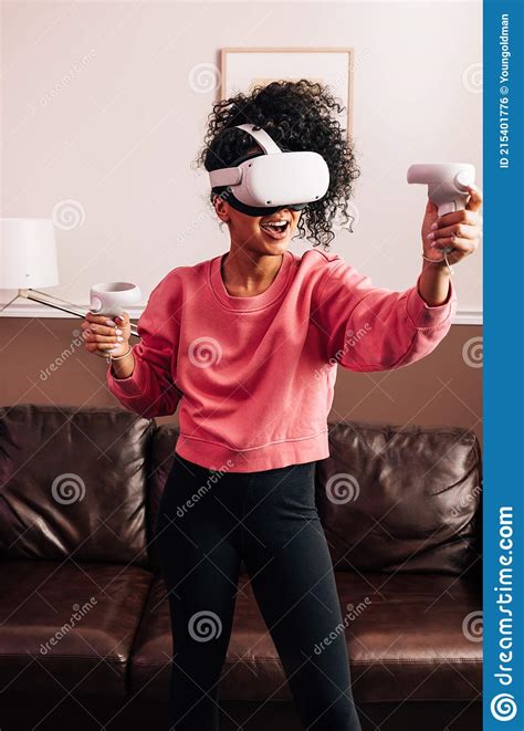 Woman With Vr Goggles And Controllers In Living Room Stock Photo