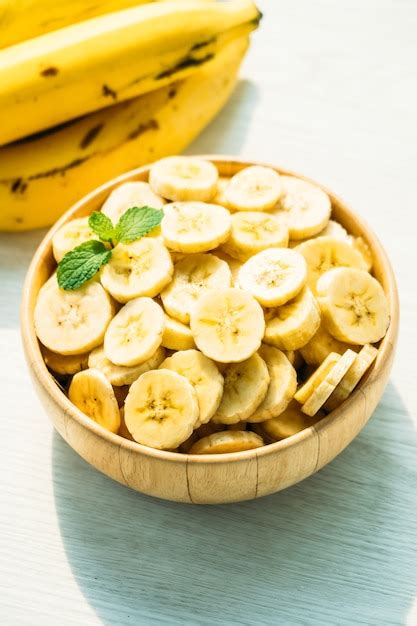 Fatias de banana amarela crua na tigela de madeira Foto Grátis