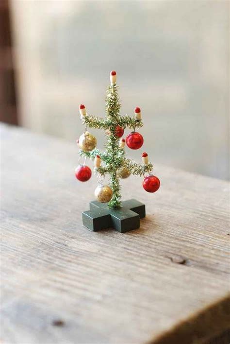 A Small Christmas Tree Sitting On Top Of A Wooden Table