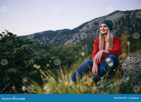 A Mulher Loura Nova Bonita Senta Exterior No Fundo Da Montanha E Da