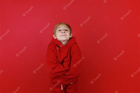 Premium Photo A Boy In A Red Suit Folded His Hands In Front Of Him