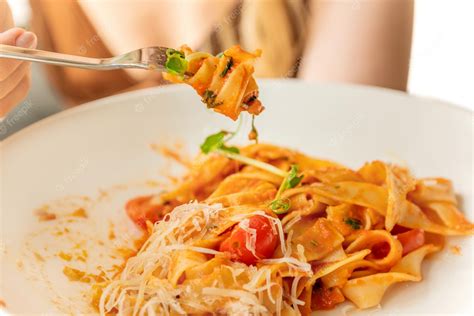 Premium Photo Woman Eats Pasta Twisting Spaghetti On Fork