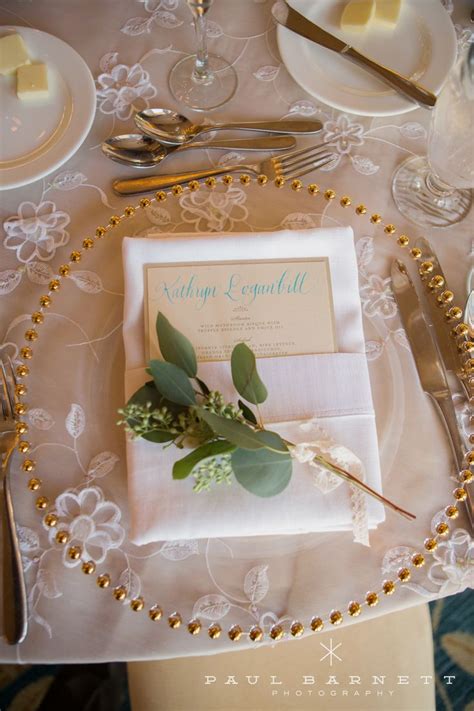 A Place Setting With Silverware Napkins And Gold Beaded Place Settings