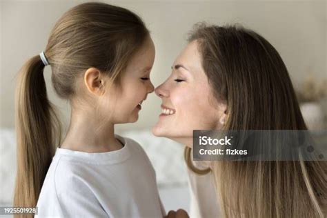 Cheerful Loving Mom Kissing Pretty Little Daughter Kid With Faces Stock