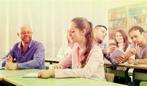 Estudantes Adultos Que Escrevem Na Sala De Aula Foto De Stock Imagem