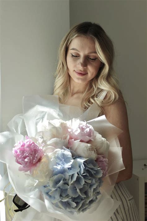 Portrait Of A Pretty Blonde With Long Hair And A Delicate Bouquet Of Peonies Stock Photo Image