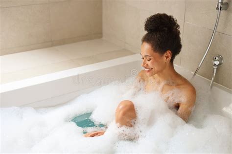 Woman Enjoying A Foamfilled Bath In A Bathtub Relaxing In The Bathroom