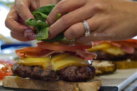 Putting toppings on gourmet hamburger Stock Photo by RLTheis | PhotoDune