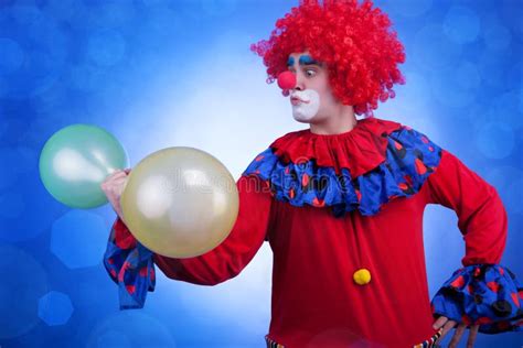 Payaso Con Los Globos a Disposición En Fondo Azul Imagen de archivo