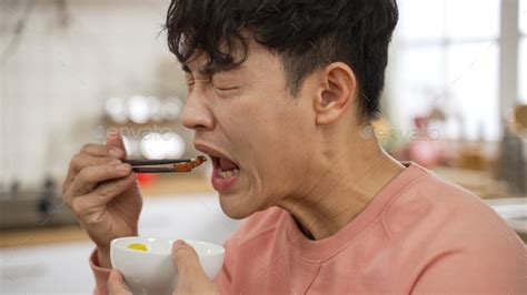 male making funny face tasting spicy food Stock Photo by primagefactory