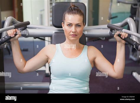 Fit Brunette Using Weights Machine For Arms Stock Photo Alamy