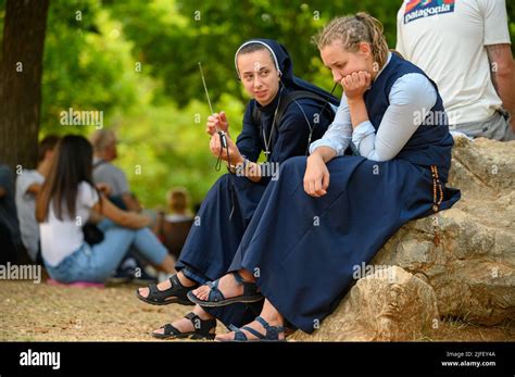 Dos jóvenes monjas entre otros peregrinos escuchando una catequesis