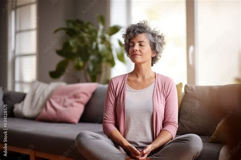 Middle Aged Woman Meditating At Home With Eyes Closed Relaxing Body