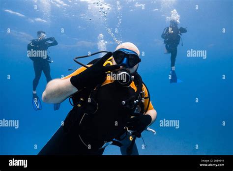 Scuba diver swimming underwater with bubbles while exploring deep clear ...