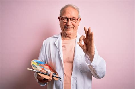 Un Artista Mayor De Pelo Gris Pintando Con Paleta De Pintor Sobre Fondo