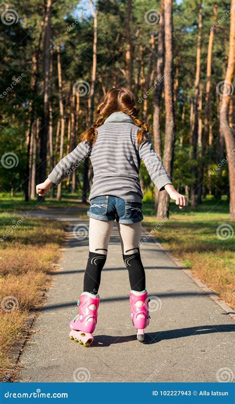 Redhead Girl With Pigtails Skates In The Park On Rollers Stock Image