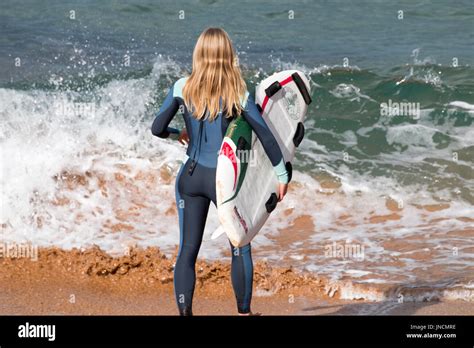 Rear View Of Blonde Australian Girl Stood On A Beach Holding Her Stock Photo Alamy