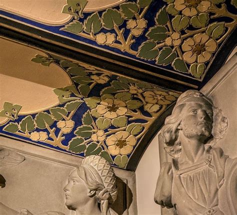 Two Statues Sitting Next To Each Other Under A Painted Ceiling