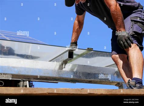 Installation of a glass roof for the terrace Stock Photo - Alamy