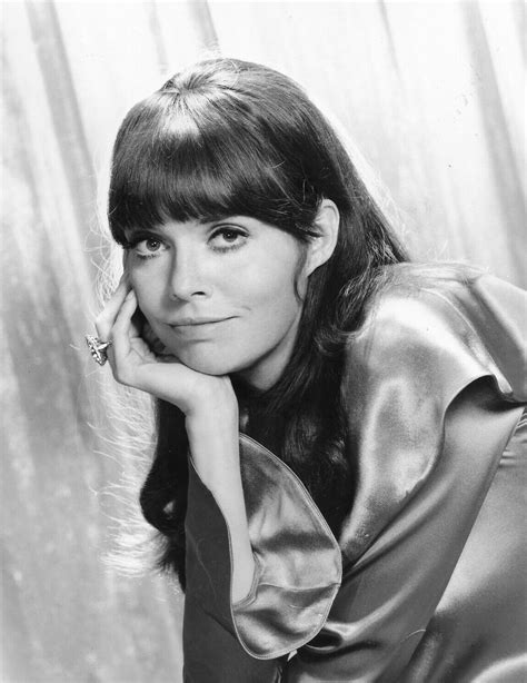 an old black and white photo of a woman with her hand on her chin looking at the camera