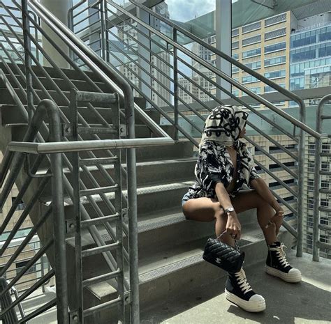 A Woman Sitting On The Steps In Front Of Some Stairs