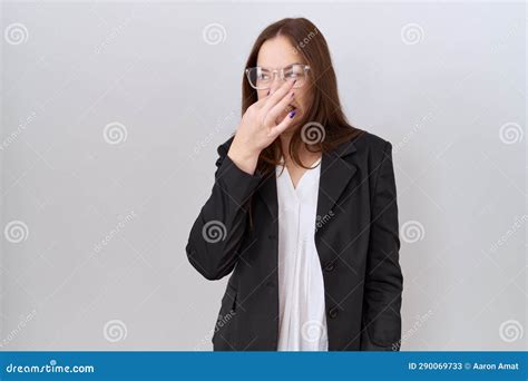 Beautiful Brunette Woman Wearing Business Jacket And Glasses Smelling