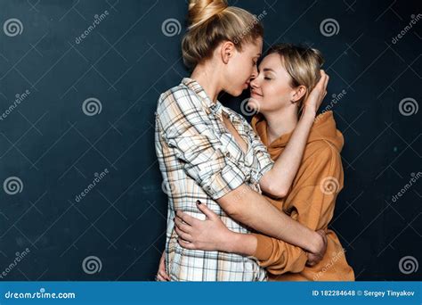 Loving Lesbian Girls Hugging Standing On Background Of Blue Wall Equal Opportunity Concept