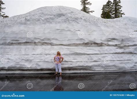 Cute Blonde Tourist Woman Poses And Stands Next To A Large Mound Of