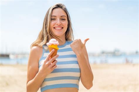 Mujer Bonita Joven Con Un Helado De Cucurucho Al Aire Libre Apuntando