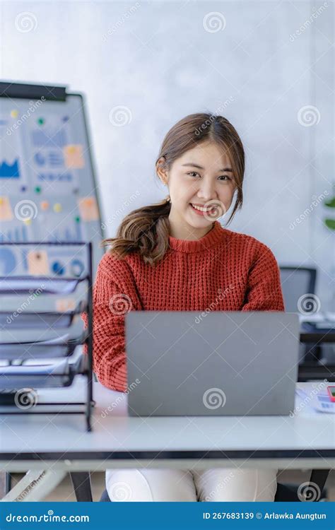 Pretty Smiling Asian Female Accountant Working On Laptop Computer In