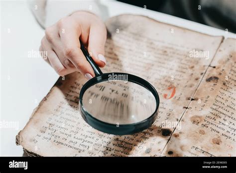 Historian Scientist Reading Antique Book With Magnifying Glass