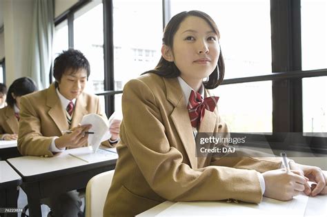 High School Students Sitting At Desk In Class Side View Front View High