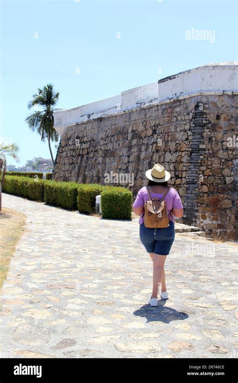 Adult Latina Woman Wearing Sunglasses And Sombrero Walks The Historic Streets Of Acapulco