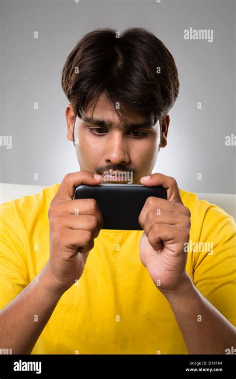 Man playing video game on a mobile phone Stock Photo - Alamy