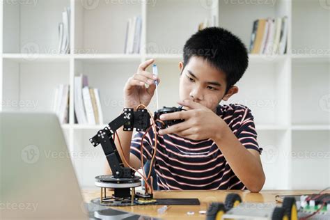 Asian teenager doing robot project in science classroom. technology of ...