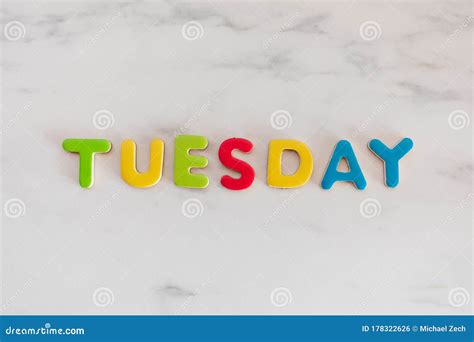 Tuesday Word Written With Colorful Letters On White Marble Stone