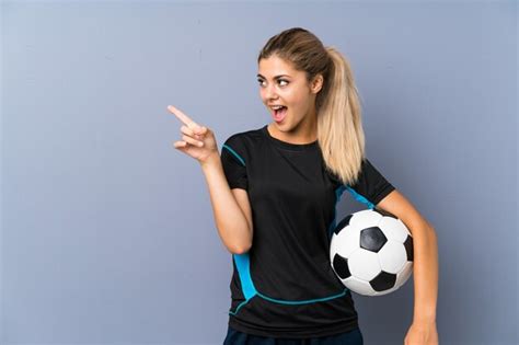 Premium Photo Blonde Football Player Teenager Girl Surprised And Pointing Finger To The Side