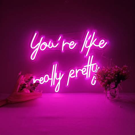 A Pink Neon Sign That Says You Re Like Really Pretty With Flowers In