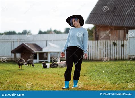 Young Beautiful Girl In A Village Holding A Basket With Chicken Eggs