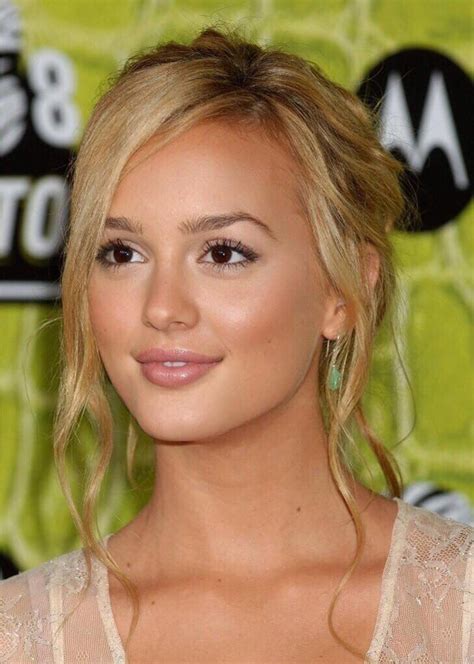 A Close Up Of A Person With Blonde Hair And Eyeshade Wearing A White Dress