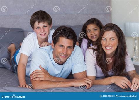 Familia Feliz Que Miente En Cama Foto De Archivo Imagen De Cama Casa