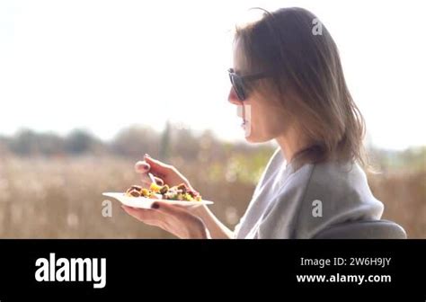 Girl In Sunglasses Eating Mature Woman With Glasses Eats A Salad From A Plate And Enjoys The