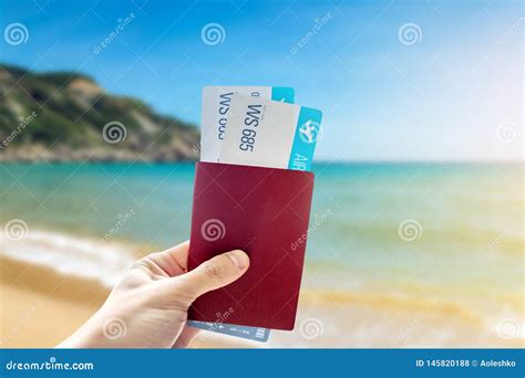 Mano Que Celebra Un Pasaporte Y Dos Billetes De Avi N En Un Fondo Azul