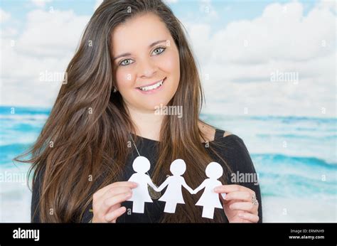 Brunette Holding An Origami Paper Figure In Front Of Oceanic Cloud Background Stock Photo Alamy