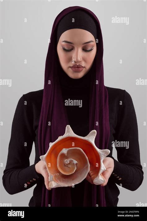 Pretty Stylish Muslim Woman Wearing Hijab And Holding A Seashell And