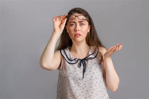 Mensen En Emoties Een Jonge Brunette In Een Blouse Met Een Bril In Haar Handen Steekt Haar