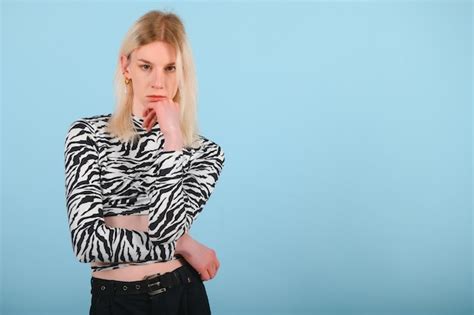 Jovem transgênero lgbt olhando para a câmera enquanto posa isolado sobre fundo de cor nude